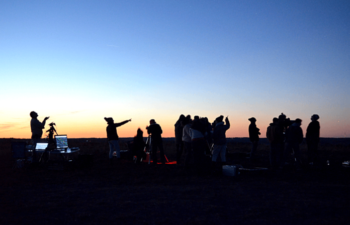 Dr. Matt Marone, left, points out stars to his astronomy (Physics 115) students during an outdoor lab class in January.