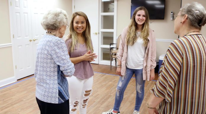 Mercer students, senior center residents forge friendships through new program Mercer students Ava Nguyen, in center, and Elise Colquitt talk with residents at Carlyle Place.