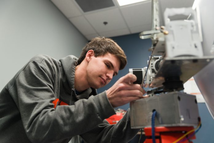 =Colin Petherbridge works in the robotics club lab on Mercer's Macon Campus.