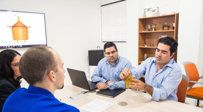 Alumnus helps support clinical trial for possible COVID-19 treatment Three men talk at a conference table