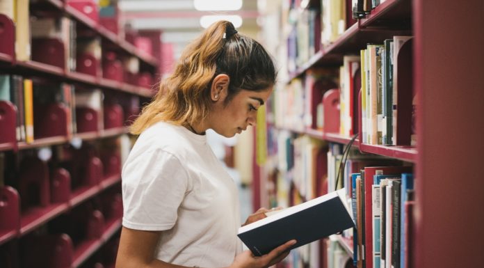 5 feel-good books to read while social distancing Woman looking at book in library