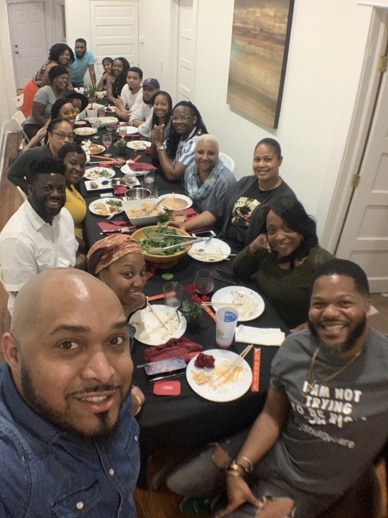 Your Soul Care Community founder Marcus Johnson (front right), a McAfee graduate, and community members are shown at one of the organization's family dinners prior to the COVID-19 pandemic.