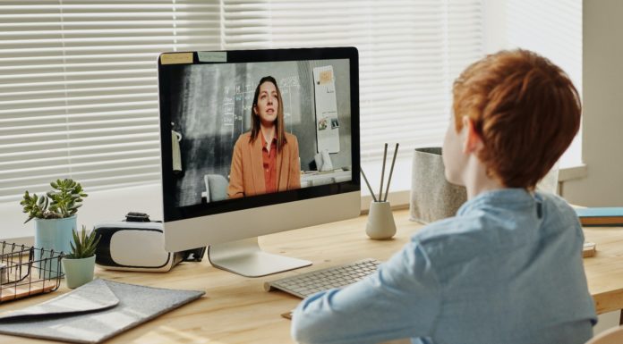 Tips to improve your child’s engagement during virtual learning Photo of child sitting by table while looking at the computer