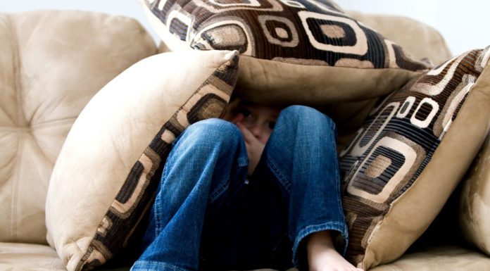 6 ways to encourage your child during the COVID-19 pandemic child on couch covering up with pillows