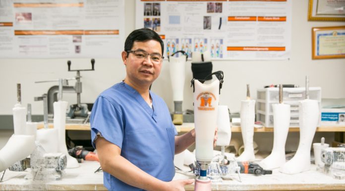 Professor develops prosthetic leg, hand that helps thousands | Mercer Made Dr. Vo holds a prosthetic leg