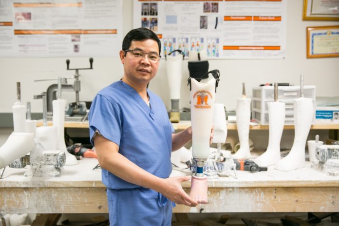 Dr. Vo holds a prosthetic leg