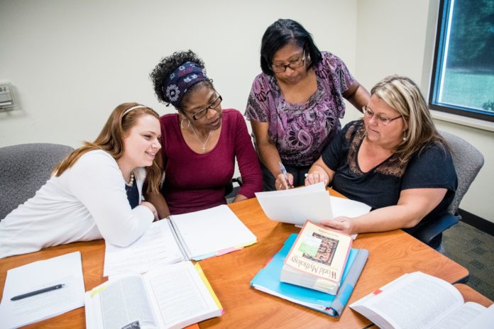 Four female students look at a paper