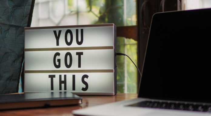 How to get past negativity in your job | Ask Kelly Black and white laptop in front of sign that says, "You got this."