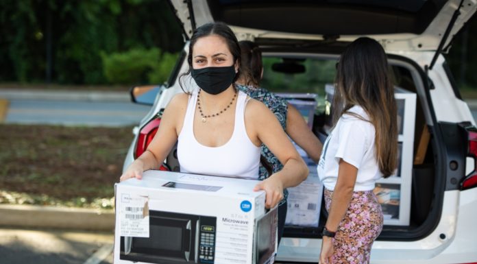 One question you should ask yourself at the start of freshman year | Ask Kelly A young woman carries a microwave in a box