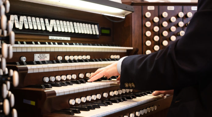 Professor studies role of music in Christian worship hands play the organ