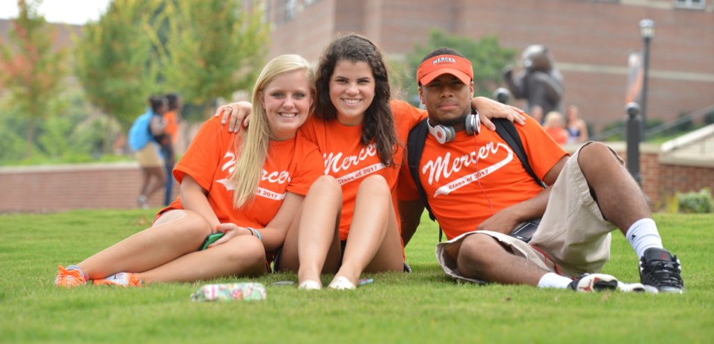 Three students sit on Mercer's lawn