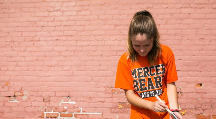 This year, Be A Good NeighBear offers two Saturdays of service A female student wearing an orange Mercer Bears shirt paints a railing