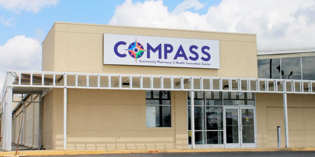 A tan building with a sign on it reading "Compass"