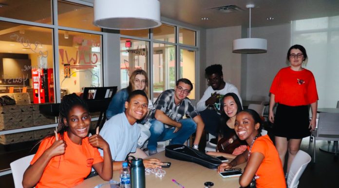 Music and Lyrics club creates space for non-music majors with musical interests A group of smiling students sit around a table