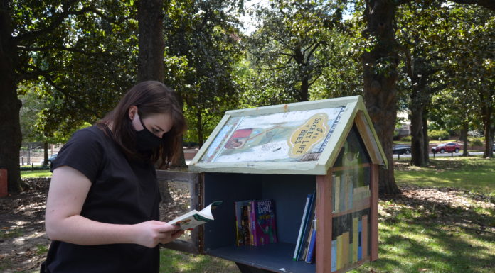 Professor develops service learning project on Little Free Libraries Malia Ayers, a sophomore education major, checks the inventory at the Little Free Library near the playground at Tattnall Square Park.