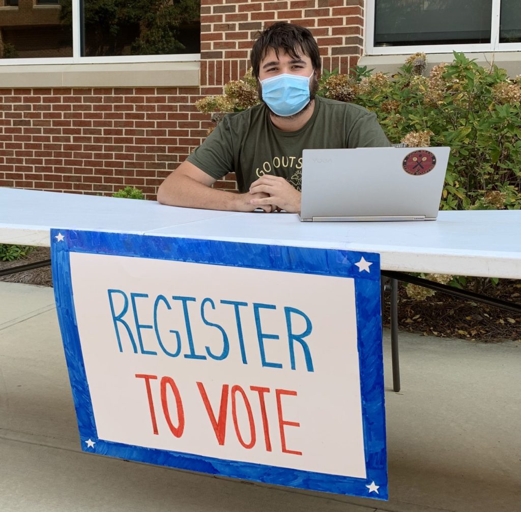 Trevor Langill, a senior international affairs major in Dr. Grant's Campaigns and Elections course, works a voter registration table near Godsey Science Center on Oct. 5.