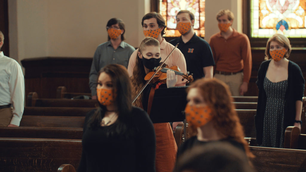 Violist plays amid masked singers