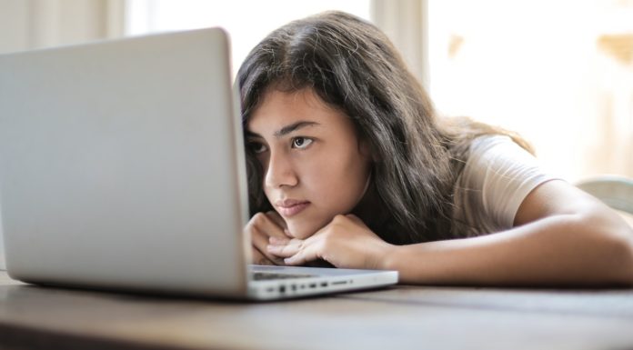 How (and why) to stay motivated in a class that doesn’t interest you | Ask Kelly woman puts head on the table while looking at a laptop