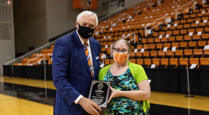 Staff members recognized with Mercer Spirit Awards president underwood hands donna terrill an award plaque