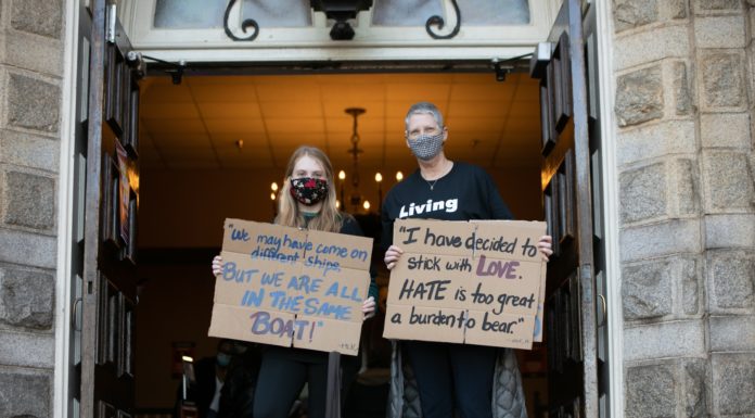 Find your voice and fearlessly raise it against injustice Two women hold signs. One reads, "We may have come on different ships but we're all in the same boat." The other reads, "I have decided to stick with love. Hate is too big a burden to bear."