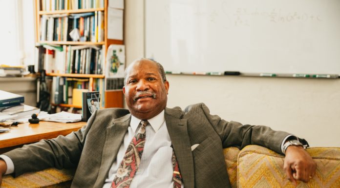 How Dr. Kedrick Hartfield became the longest-serving Black professor at Mercer Dr. Kedrick Hartfield sits on a couch in his office