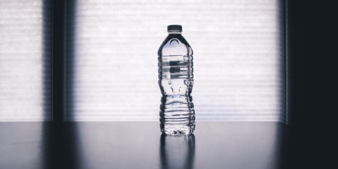 clear disposable water bottle on black table