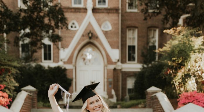 Graduate Spotlight: Madison Toole A young woman in a white dress wears an orange stole and a graduate cap
