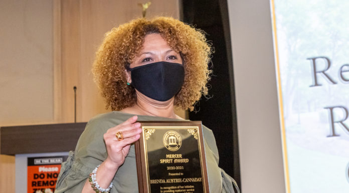 Staff members honored with Mercer Spirit Award A woman holds a plaque