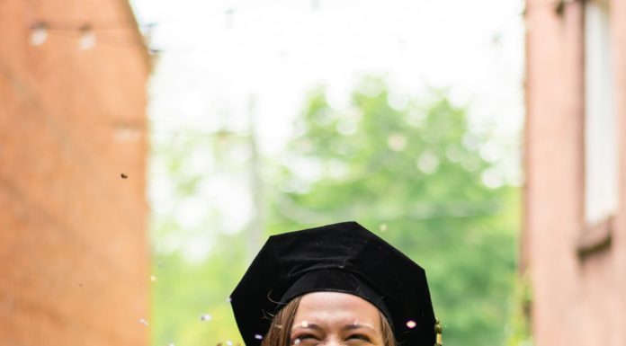 Graduate Spotlight: Savannah Eichhorn A woman wearing a black graduation cap and gown laughs as she throws confetti