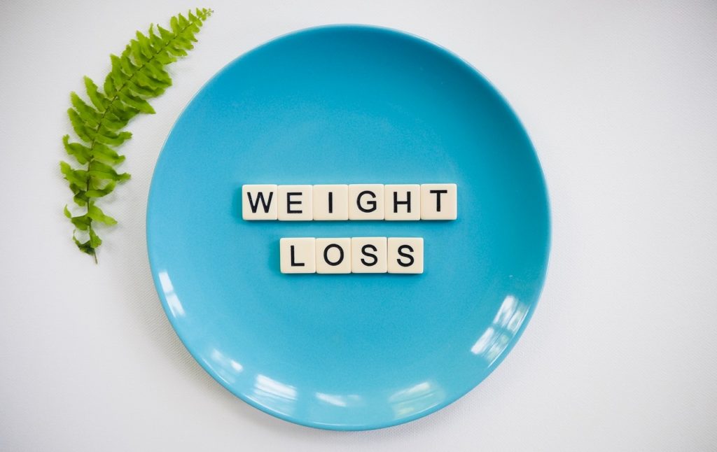 blue plate has scrabble letters on it that spell out weight loss