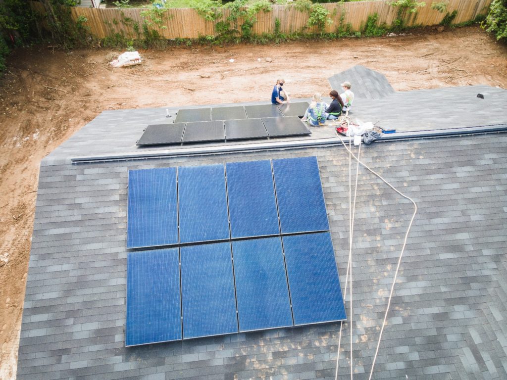Aerial view of student installing solar panels on a roof