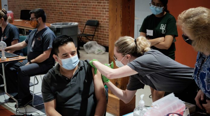 Faith in the Vaccine Ambassadors host vaccine clinics and other community events A community member receives the COVID-19 vaccine during a vaccination clinic for the Hispanic community on the Macon campus on July 15.