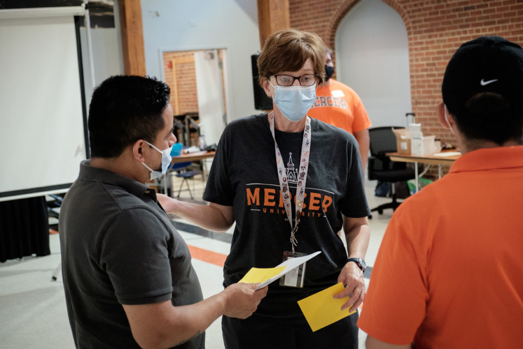 A Mercer staff member talks with community members during the vaccination clinic. 