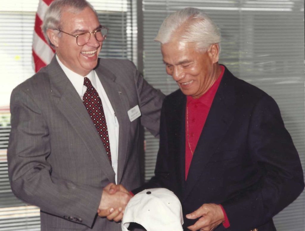 Raleigh Mann, Mercer's former director of Alumni Services, presents His Royal Highness Sultan Azlan Shah with a Mercer baseball hat during the luncheon for the Malaysian Olympic team and dignitaries on the Atlanta campus in 1996.