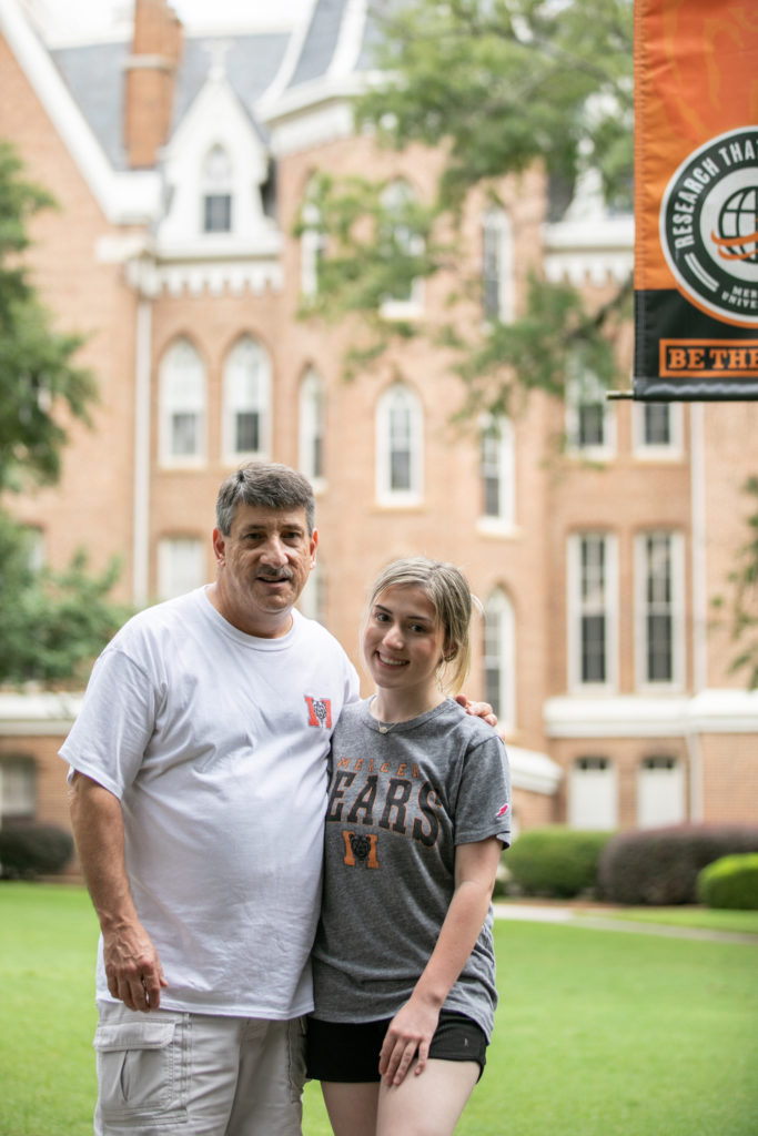 father and daughter stand in front of mercer's administration building