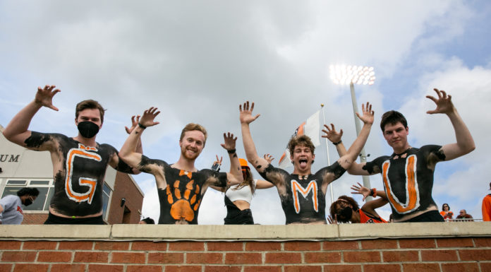 Three things to know about Mercer vs. Wofford football game day male students with their chests painted orange and black make bear claws for the camera