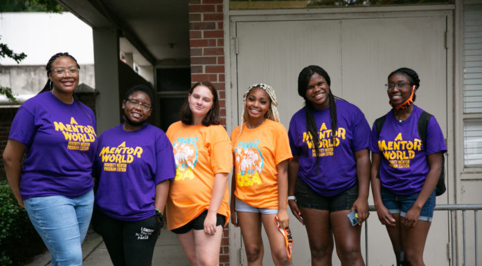 Event celebrates first-generation students who are blazing trails for their families students in orange and purple shirts stand in front of a building