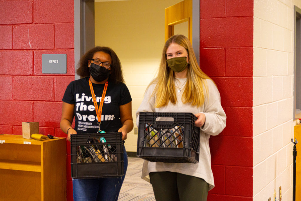 Lakeeya Brockington, a sophomore majoring in marketing, left, and McKenna Kaufman, a junior double-majoring in journalism and international affairs, move books at the Brookdale Resource Center in Macon on Dec. 3.