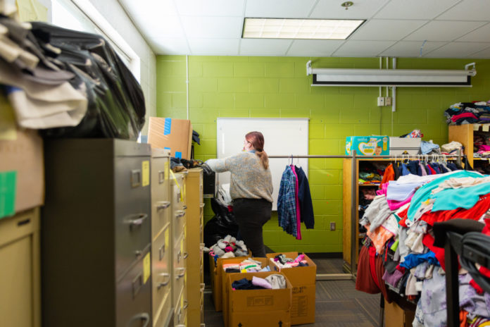 Lara Edgeman, a junior majoring in education, moves clothes at the Brookdale Resource Center in Macon on Dec. 3.
