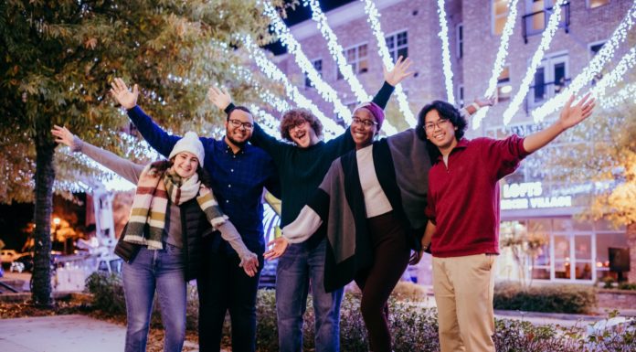 Use the holiday break to relax. You deserve it | Ask Kelly Three students smile amid the holiday lights in Mercer Village