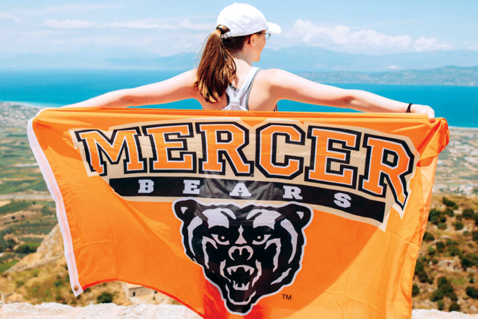 college student holds out mercer flag