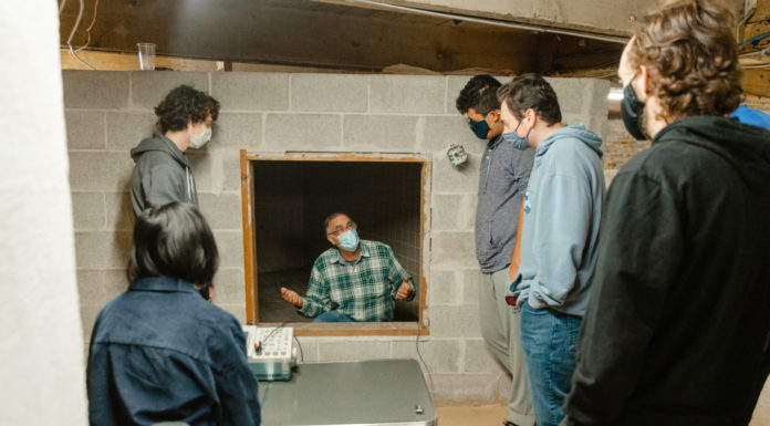 Physics class conducts experiment in reverb chamber at Mercer Music at Capricorn a professors sits inside a reverb chamber and talks to students on the outside