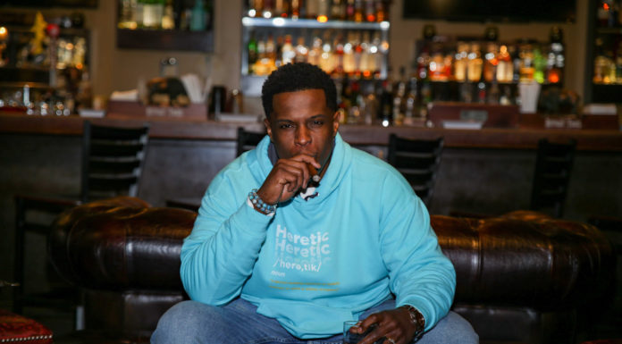 McAfee alumnus challenges traditional theology — and feel free to call him a heretic Kristian Smith smokes a cigar in front of a bar