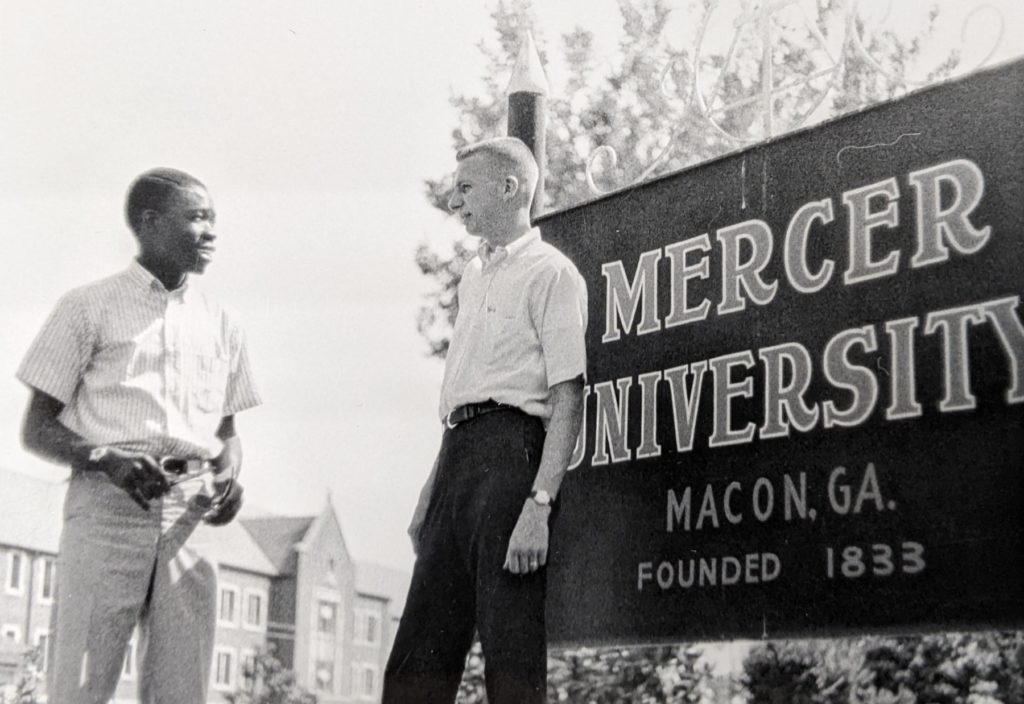 Sam Oni and Jim Jordan stand in front of a Mercer University sign in this black and white photo