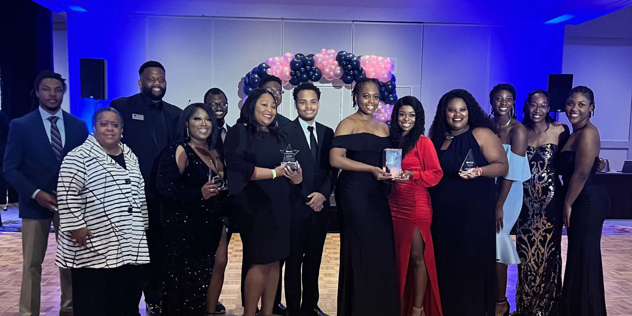 Group of students posing with award trophy.