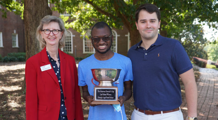 Mercer Law wins annual Law School Food Frenzy Group photo of three people holding the Attorney General's Cup trophy for Law School Food Frenzy