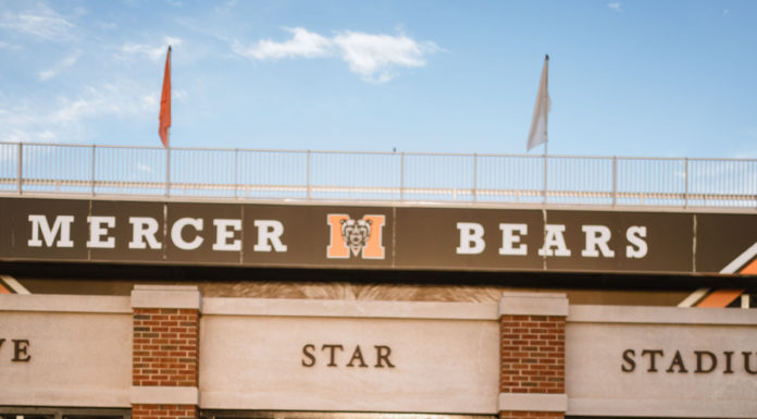 Graduate Spotlight: Hannah Yontz A young woman in a graduate gown stands in front of five star stadium