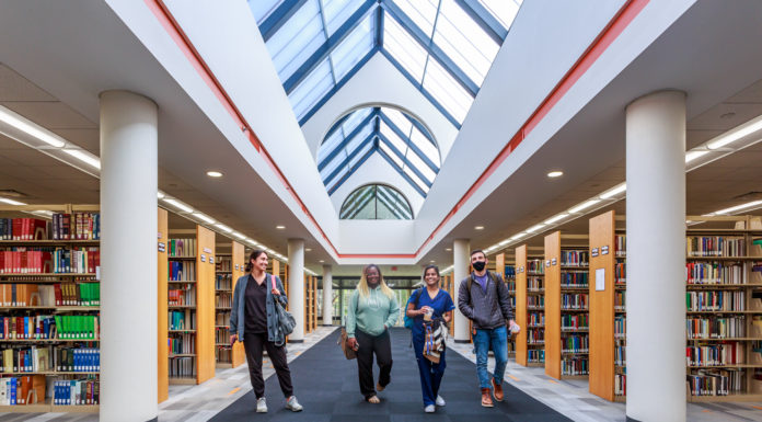 Swilley Library undergoes major renovation with students in mind Four students walk a hallway in between shelves of books