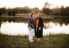 Daughter graduates from College of Nursing 12 years after her mom Two women stand side by side in front of a lake. The younger woman on the right wears a graduation gown.