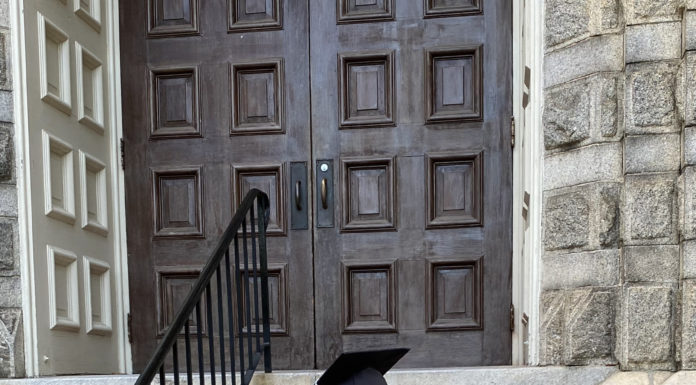 Graduate Spotlight: Shelby Ryals a young woman wearing a graduation cap, gown and cords sits on the steps